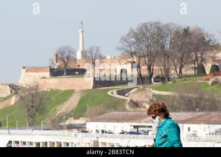 Belgrade, Serbie - 18 mars 2020: Les femmes portent un masque de protection tout en marchant avec la forteresse de Kalemegdan en arrière-plan, à l'époque du coronavirus Banque D'Images