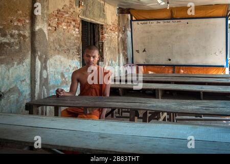 Battambang, Cambodge, Asie: Jeune moine bouddhiste assis seul dans une salle de classe d'une école de plein air dans le temple Wat Tahm-rai-SAW Banque D'Images