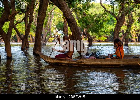 Un père et une fille pagayer à travers la forêt inondée au sud de Kampong Phluk, au Cambodge. Banque D'Images