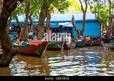 Les femmes attendent de donner aux touristes des promenades en bateau à travers la forêt inondée au sud de Kampong Phluk, au Cambodge. Banque D'Images