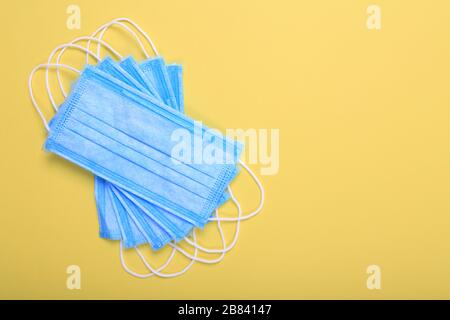 Masques médicaux pour la protection contre la grippe et le coronavirus sur fond jaune. Masque de protection chirurgical. Prévention de la propagation du virus et du pandemi Banque D'Images