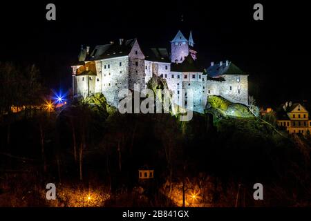 Vue de nuit sur une ville Loket et le château de Loket (Hrad Loket, Burg Elbogen), château imprégnable sur un rocher massif, illuminé par des lampes de rue. spo Tourist Banque D'Images