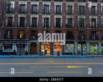 Une boutique de boucher reste ouverte au milieu d'une rue vide d'Alcalá, dans le centre-ville de Madrid, après le verrouillage du coronavirus. Depuis le 15 mars, chaque magasin non nécessaire doit rester fermé tant que l'état de l'alarme dure. Banque D'Images