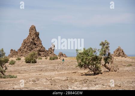 Afrique, Djibouti, Lac Abbe. Vue sur le paysage Moonlike de la formation de roches dans le lac Abbe. Un enfant est en cours d'exécution. Banque D'Images