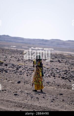 Afrique, Djibouti, Lac Abbe. Une femme marche dans le désert sur le chemin du lac Abbe Banque D'Images