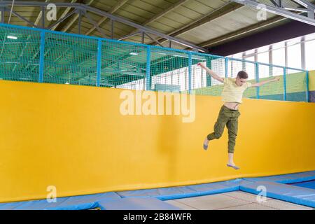 Un adolescent sautant sur le parc du trampoline dans le centre sportif Banque D'Images