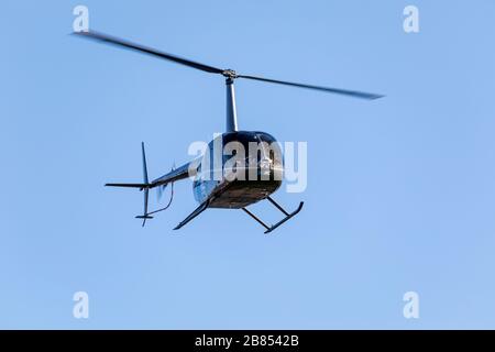 Un petit hélicoptère volant dans un ciel bleu clair Banque D'Images