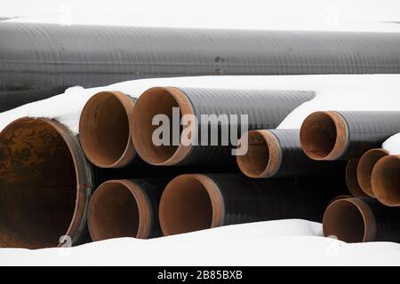 Matériaux de construction. Tuyaux industriels en plastique sous la neige Banque D'Images