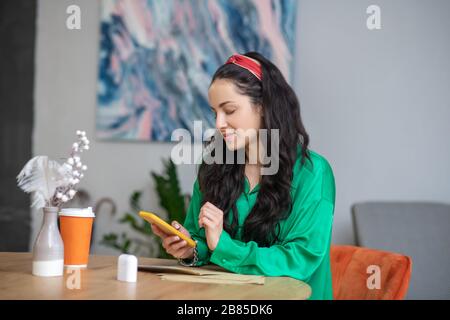 Jeune femme assise à une table au bureau. Banque D'Images