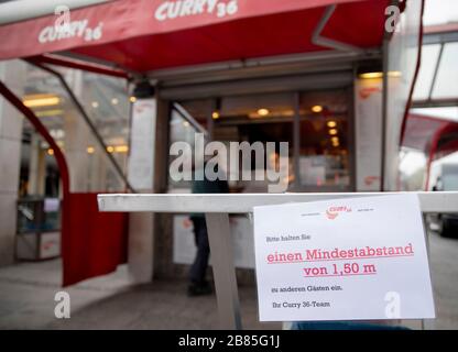 Berlin, Allemagne. 20 mars 2020. Un panneau avec l'instruction de maintenir une distance minimale de 1,5 mètres à d'autres clients se trouve sur la table d'un stand de saucisse de curry à la gare Zoologischer Garten. Pour ralentir la propagation du coronavirus, le gouvernement fédéral a considérablement limité la vie publique. Crédit: Christoph Soeder/dpa/Alay Live News Banque D'Images