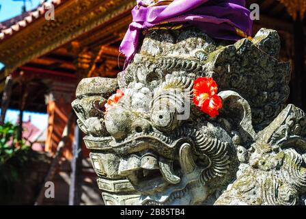 Une statue de gardien devant un temple de Bali vêtu de vêtements traditionnels Banque D'Images