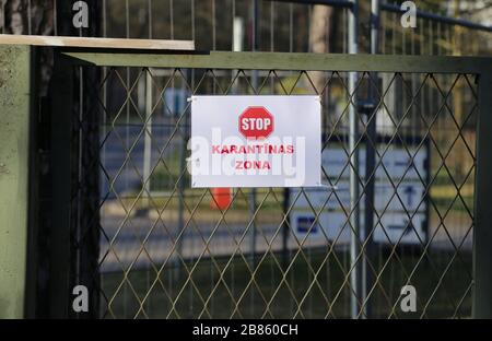 Riga, Lettonie. 19 mars 2020. Un panneau avec un panneau d'arrêt et l'inscription 'Karantinas zona' (zone de quarantaine) se trouve sur une barrière à côté de la station d'essai du Centre letton d'Infectiologie de Riga. Les personnes suspectées de Covid-19 sont testées ici. Crédit: Alexander Welscher/dpa/Alay Live News Banque D'Images