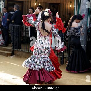 Les jeunes femmes portent des robes de flamenco et dansent des 'Sevillanas' à la foire d'avril (Feria de Abril), la foire de Séville Banque D'Images