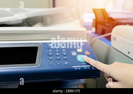 Les doigts qui pressent le bouton, l'imprimante est entièrement fonctionnelle, est important au bureau pour présenter le travail et le succès du travail. Banque D'Images