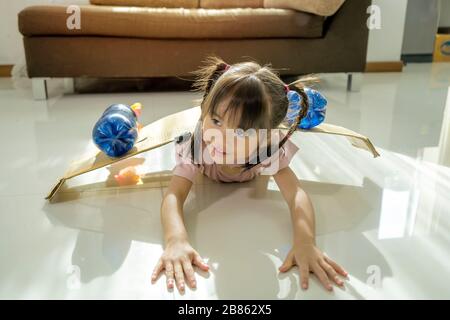Les filles asiatiques apprennent des technologies innovantes à partir d'inventions. Elle a installé des ailes de roquettes en papier, des caisses et des bouteilles en plastique. Elle est passionat Banque D'Images