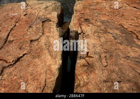 gros défaut ou rayure sur la roche. la structure de roche brune se rapproche. Pile de grosses pierres de granit. Texture sur la surface de la roche. Pierre massive avec rayures Banque D'Images