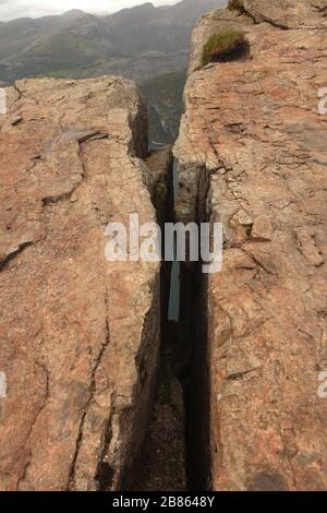gros défaut ou rayure sur la roche. la structure de roche brune se rapproche. Pile de grosses pierres de granit. Texture sur la surface de la roche. Pierre massive avec rayures Banque D'Images