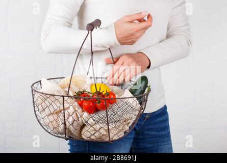 La femme garde le dos avec des légumes frais et des fuits dans des sacs textiles Banque D'Images