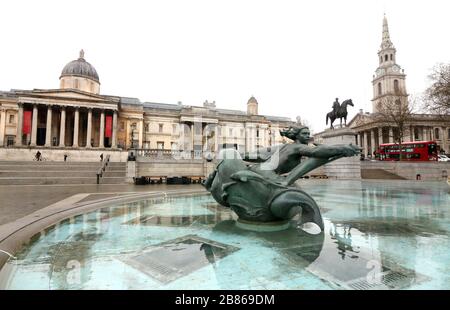 Londres, Royaume-Uni. 19 mars 2020. Vue sur la place Trafalgar, déserte, au milieu des menaces de Coronavirus à Londres. Le gouvernement britannique élabore des plans visant à faire appliquer la fermeture de restaurants, de bars et de cinémas dans la capitale et à limiter l'utilisation des transports publics. Le "London Lock Down" attendu a déjà vu de grands espaces vides où les touristes se rassemblent habituellement et désertent les rues autour des monuments en raison de la menace d'une nouvelle propagation du coronavirus. Crédit: SOPA Images Limited/Alay Live News Banque D'Images