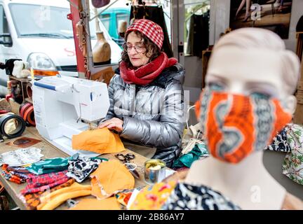 Hanovre, Allemagne. 20 mars 2020. La designer de cuir Petra Warneke de Hanovre cousse des masques de protection à son stand sur le marché hebdomadaire de Stephansplatz, qu'elle donne en échange d'un don. Crédit: Hauke-Christian Dittrich/dpa/Alay Live News Banque D'Images