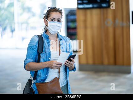 Restrictions de voyage liées à l'éclosion de coronavirus. Les voyageurs ayant un masque à l'aéroport international sont concernés par les annulations de vols et l'interdiction de voyager. COVID-19 Banque D'Images