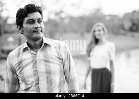 Homme indien pensant avec une belle femme debout sur le chemin de pierre au milieu du lac dans le parc Banque D'Images