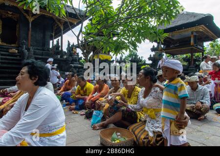 Les Balinais assis et priant pendant l'Odalan, Pura Goa Lawah, Semarapura, Klungkung Regency, Bali, Indonésie Banque D'Images