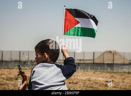 Un petit enfant a le drapeau palestinien pendant la "Grande Marche du retour" à la frontière israélo-Gaza, le 15 mai 2019 Banque D'Images