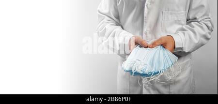 Masques médicaux. Le médecin tient dans les mains une pile de bandage de protection médicale. Banque D'Images