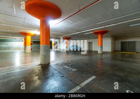 Voiture bleue d'époque garée sur un parking souterrain sombre vide Banque D'Images