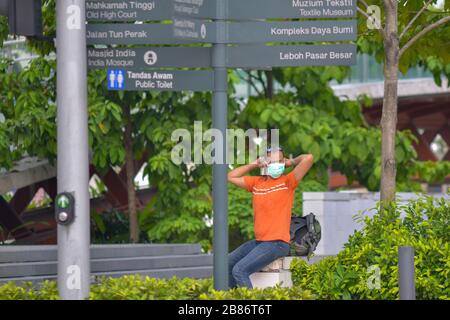 Kuala Lumpur, Malaisie. 20 mars 2020. Un homme portant un masque facial est assis près de la place de l'indépendance à Kuala Lumpur, en Malaisie, le 20 mars 2020. La Malaisie a annoncé vendredi 130 nouveaux cas confirmés de COVID-19, portant le nombre total dans le pays à 1 030, a déclaré le Ministère de la santé. Crédit: Chong Voon Chung/Xinhua/Alay Live News Banque D'Images