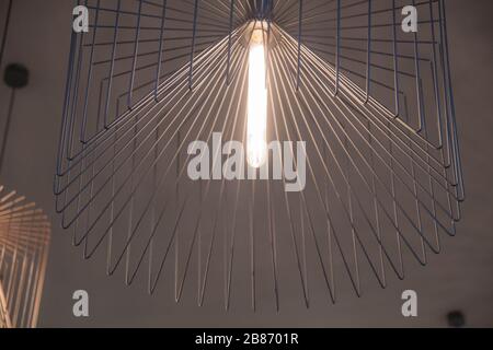 Lustre géométrique élégant en métal fin droit. Abat-jour minimal. Lampe avec ampoule en verre longue. Fond doublé Banque D'Images