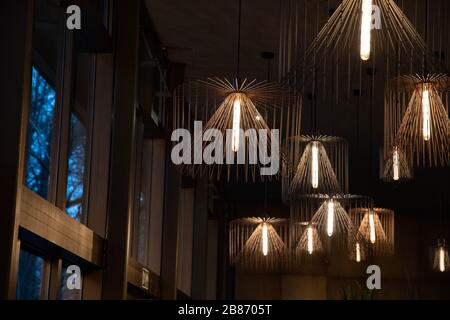 Chandeliers à proximité des fenêtres. Abat-jour en métal contemporain. Lampes avec ampoules à lumière longue. Formes géométriques de fils de différentes tailles. Intérieur Banque D'Images