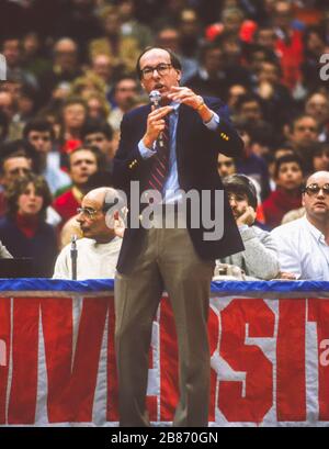 SYRACUSE, NEW YORK, USA, 1985 - le entraîneur de basket-ball de l'Université de Syracuse Jim Boeheim prend le microphone pour avertir la foule de ne pas jeter d'objets sur le terrain pendant le match de Georgetown 1/28/85. Banque D'Images