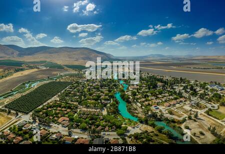 Panorama aérien de Kibbutz NIR David dans le nord d'Israël avec des vergers et l'eau turquoise de la rivière Amal Banque D'Images