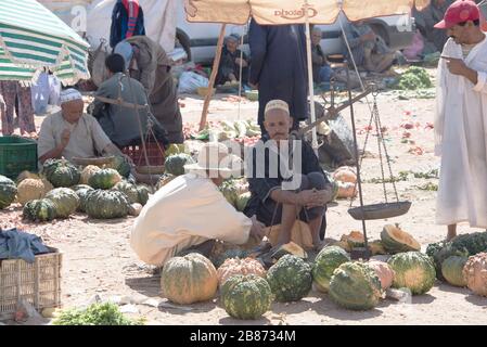 Essouria, Maroc - septembre 2017: Un agriculteur siège en servnig pour vendre ses produits sur le marché ouvert hebdomadaire berber à l'extérieur d'Essaouira au Maroc. Les femmes Banque D'Images