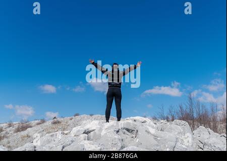 fille avec bras large ouvert sur une montagne rocheuse Banque D'Images