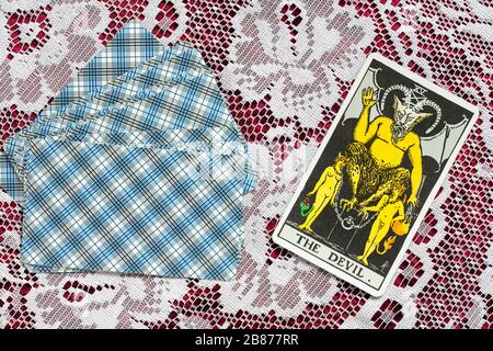Cartes de Tarot Rider conçues par Pamela Colman Smith sous la supervision d'Arthur Edward Waite sur un tissu avec la carte de tarot du Diable tournée Banque D'Images