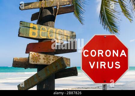 Image de concept composite avec un panneau d'avertissement de coronavirus du virus Corona en face de la plage tropicale et de l'océan, montrant les restrictions de voyage dues à une pandémie Banque D'Images