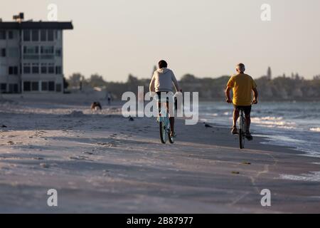 Lido Beach, Floride, États-Unis - 20 mars 2020. Un couple fait des promenades en vélo le long de Lido Beach juste après le lever du soleil. Banque D'Images