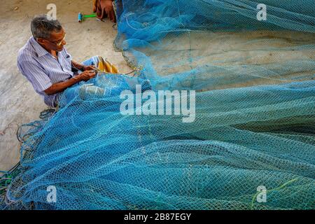 Jaffna, Sri Lanka - février 2020: Un homme répare des filets dans la zone de pêche de Jaffna le 23 février 2020 à Jaffna, Sri Lanka. Banque D'Images