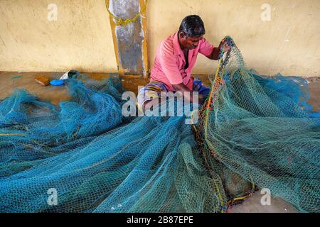 Jaffna, Sri Lanka - février 2020: Un homme répare des filets dans la zone de pêche de Jaffna le 23 février 2020 à Jaffna, Sri Lanka. Banque D'Images