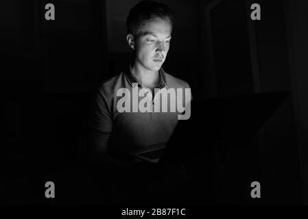 Young handsome man dans le salon sombre Banque D'Images