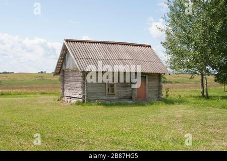 petite petite vieille cabane en bois raster dans le champ central près de bouleau Banque D'Images