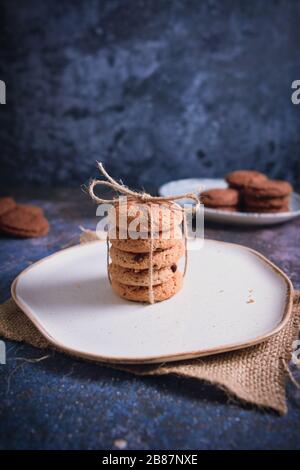 Biscuits magnifiquement empilés avec du chocolat sur table en bois. Cookies aux pépites de chocolat Vintage Color Banque D'Images