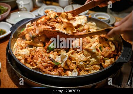 Flipper de bois sauté un poulet barbecue Dakgalbi sur une poêle de la cuisine coréenne Banque D'Images