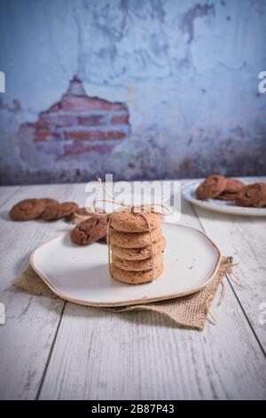 Biscuits magnifiquement empilés avec du chocolat sur table en bois. Cookies aux pépites de chocolat Vintage Color Banque D'Images