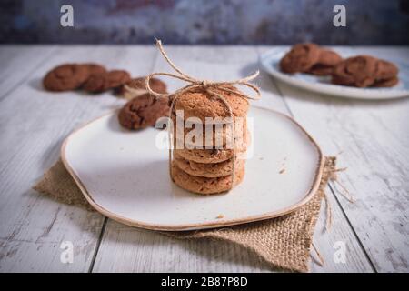 Biscuits magnifiquement empilés avec du chocolat sur table en bois. Cookies aux pépites de chocolat Vintage Color Banque D'Images