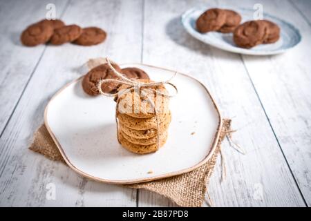 Biscuits magnifiquement empilés avec du chocolat sur table en bois. Cookies aux pépites de chocolat Vintage Color Banque D'Images