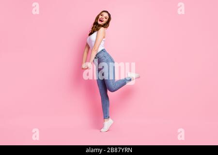 Photo pleine forme de la dame funky marcher dans la rue tendance cool look été chaud chaud temps usure blanc débardeur-top jeans chaussures isolé rose vif Banque D'Images